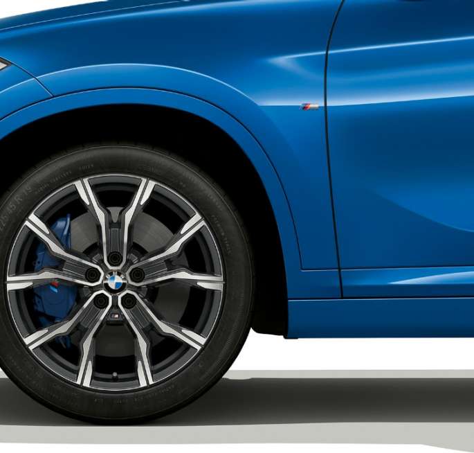 BMW X1, M Sport-útfærsla, létt álfelga BMW X1, M Sport-útfærsla, hliðarsýn með nærmynd af léttri álfelgu