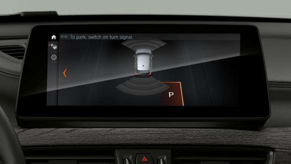 BMW X1, bílastæðaaðstoð á skjáum og stjórnhnappar. BMW X1, innanrými með áherslu á „Driving Assistant Plus“ á skjáum og stjórnhnappar.