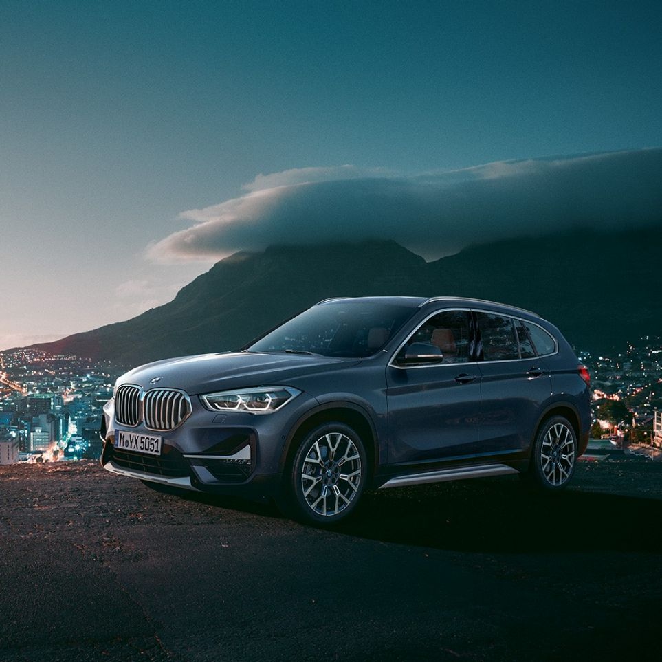 BMW X1, skásett sjónarhorn á hliðina. BMW X1, skásett sjónarhorn á hliðina með þéttbýli í bakgrunni.
