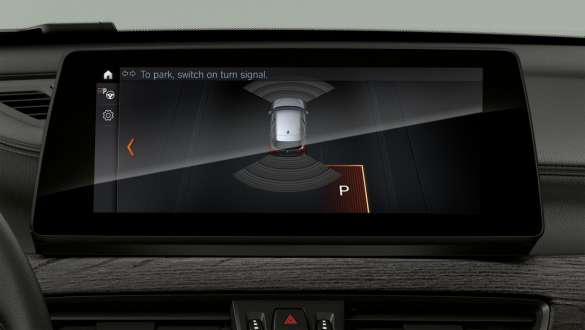 BMW X1 F48, bílastæðaaðstoð á skjáum og stjórnhnappar BMW X1 F48 LCI, innanrými með áherslu á „Driving Assistant Plus“ á skjáum og stjórnhnappar