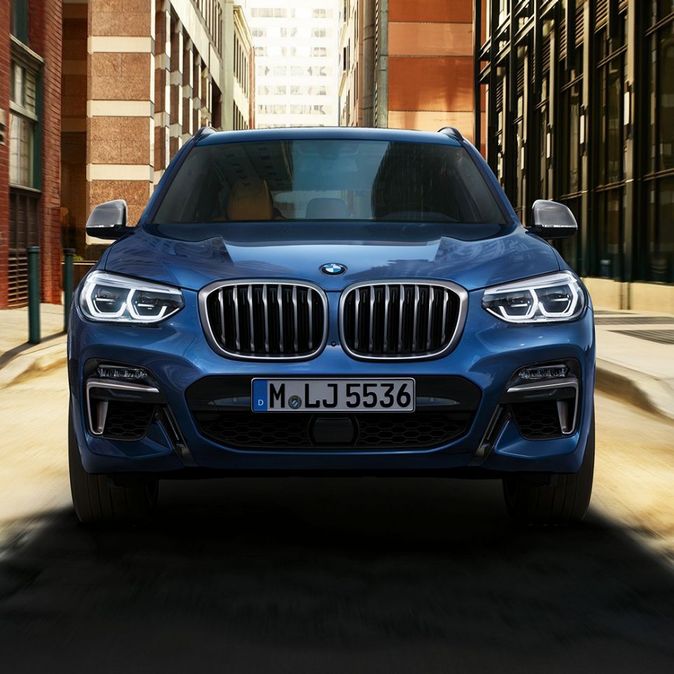 BMW X3 M40i, sjónarhorn á framhluta fyrir framan borgarlandslag BMW X3 M40i, sjónarhorn á framhluta fyrir framan borgarlandslag