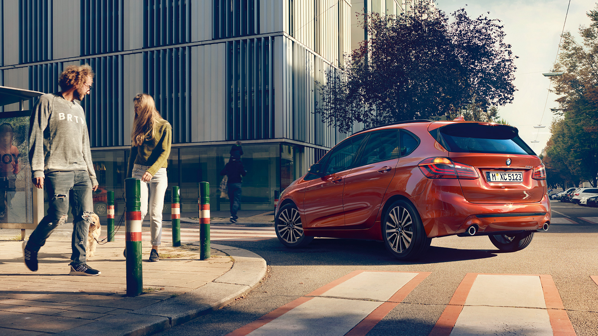 Aksturseiginleikar BMW 2 Series Active Tourer Aksturseiginleikar sanseraðs sólsetursappelsínuguls BMW 2 Series Active Tourer 220i 2018 F45, skásett sjónarhorn á afturhluta