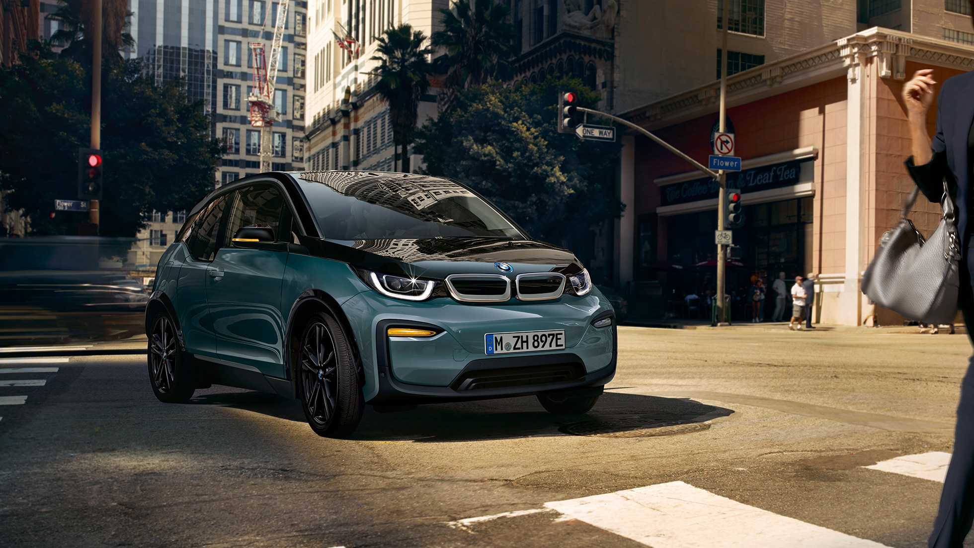 BMW i3 2018 í akstri, skásett sjónarhorn á framhluta BMW i3 I01 2018, Jucaro-drapplitaður með frostgráum sanseruðum áherslulit, skásett sjónarhorn á framhluta í innanbæjarakstri