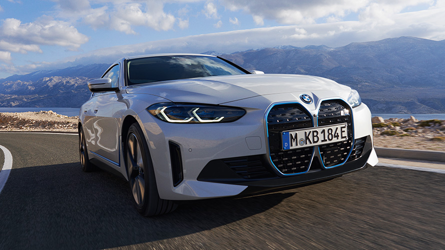 Þriggja fjórðu framsýn BMW i4 eDrive40 G26 2021 akstur BMW i4 eDrive40 G26 2021 Steinefni Hvítur þriggja fjórðu framsýnisakstur