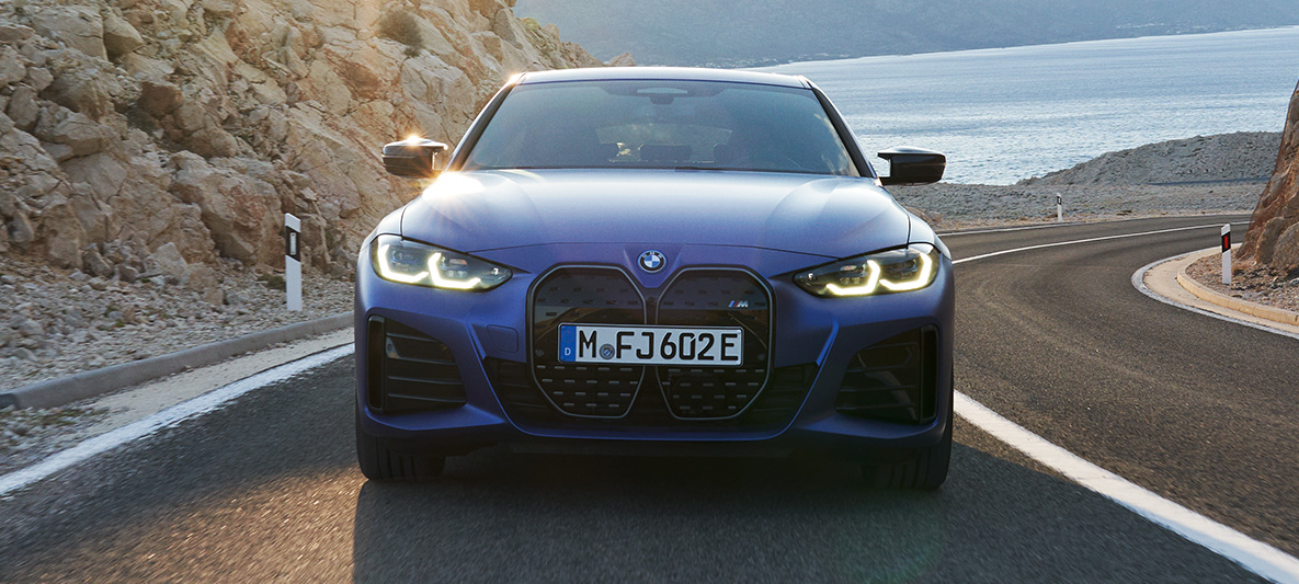 Framsýn BMW i4 M50 G26 2021 akstur BMW i4 M50 G26 2021 M Portimao Blue metallic framan útsýnið akstur á veginum