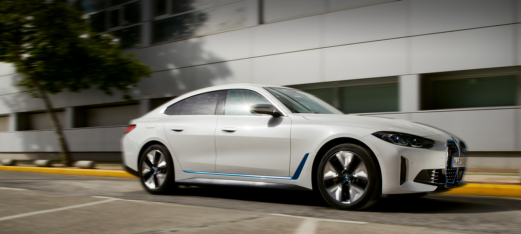 BMW i4 eDrive40 G26 2021 skásett sjónarhorn frá hlið af akstri fyrir framan hús BMW i4 eDrive40 G26 2021 skásett sjónarhorn frá hlið af akstri fyrir framan hús