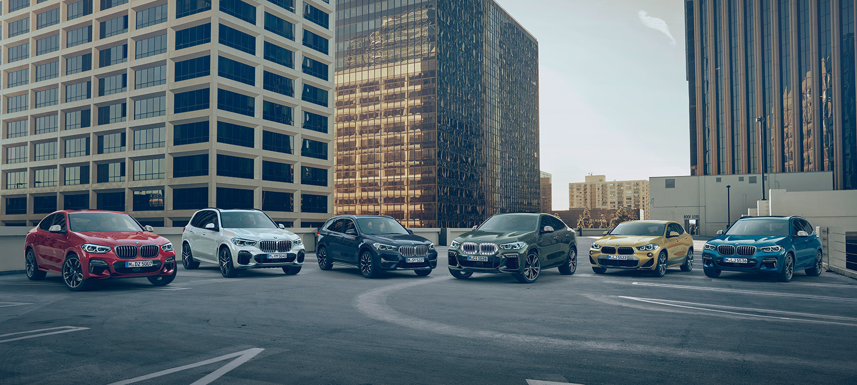BMW X-bílar á bílastæði fyrir framan byggingar BMW X-línan – BMW X-bílar á bílastæði fyrir framan byggingar