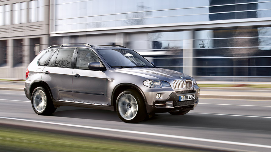 Önnur kynslóð BMW X5 E70 ekur á götu, skásett sjónarhorn á hlið BMW X-línan – önnur kynslóð BMW X5 E70 ekur á götu, skásett sjónarhorn á hlið