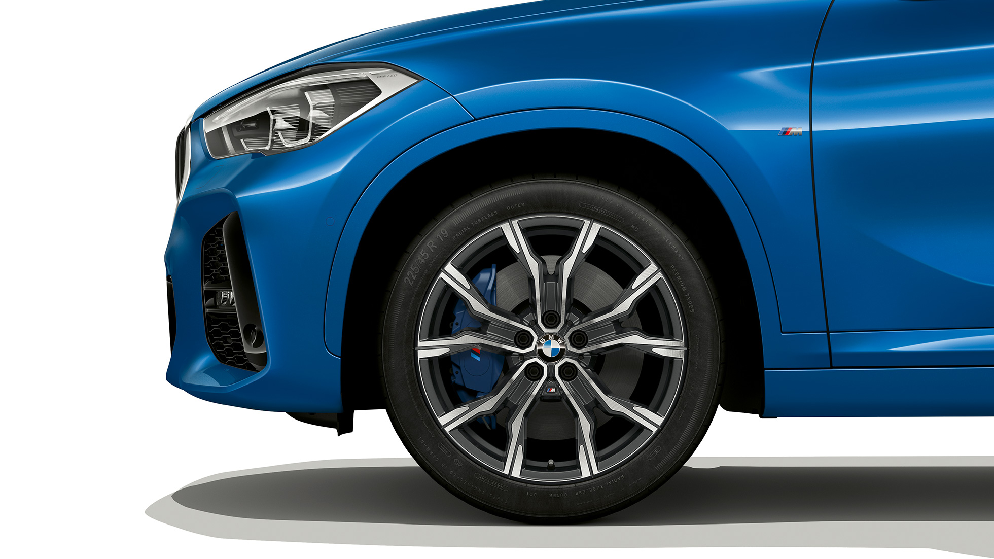 BMW X1, M Sport-útfærsla, létt álfelga BMW X1, M Sport-útfærsla, hliðarsýn með nærmynd af léttri álfelgu
