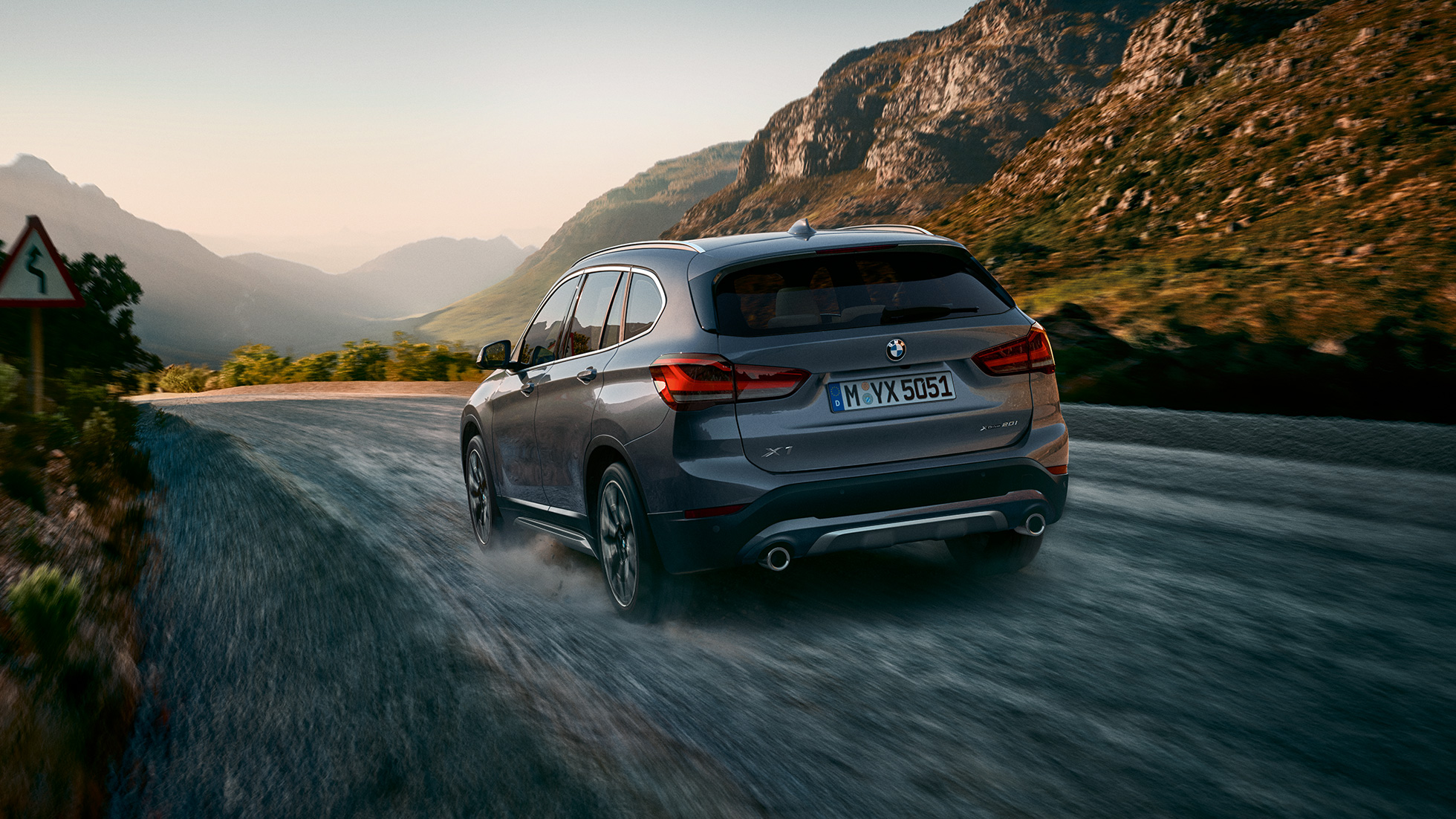 BMW X1, skásett sjónarhorn á afturhluta. BMW X1, skásett sjónarhorn á afturhluta við akstur í fjalllendi.