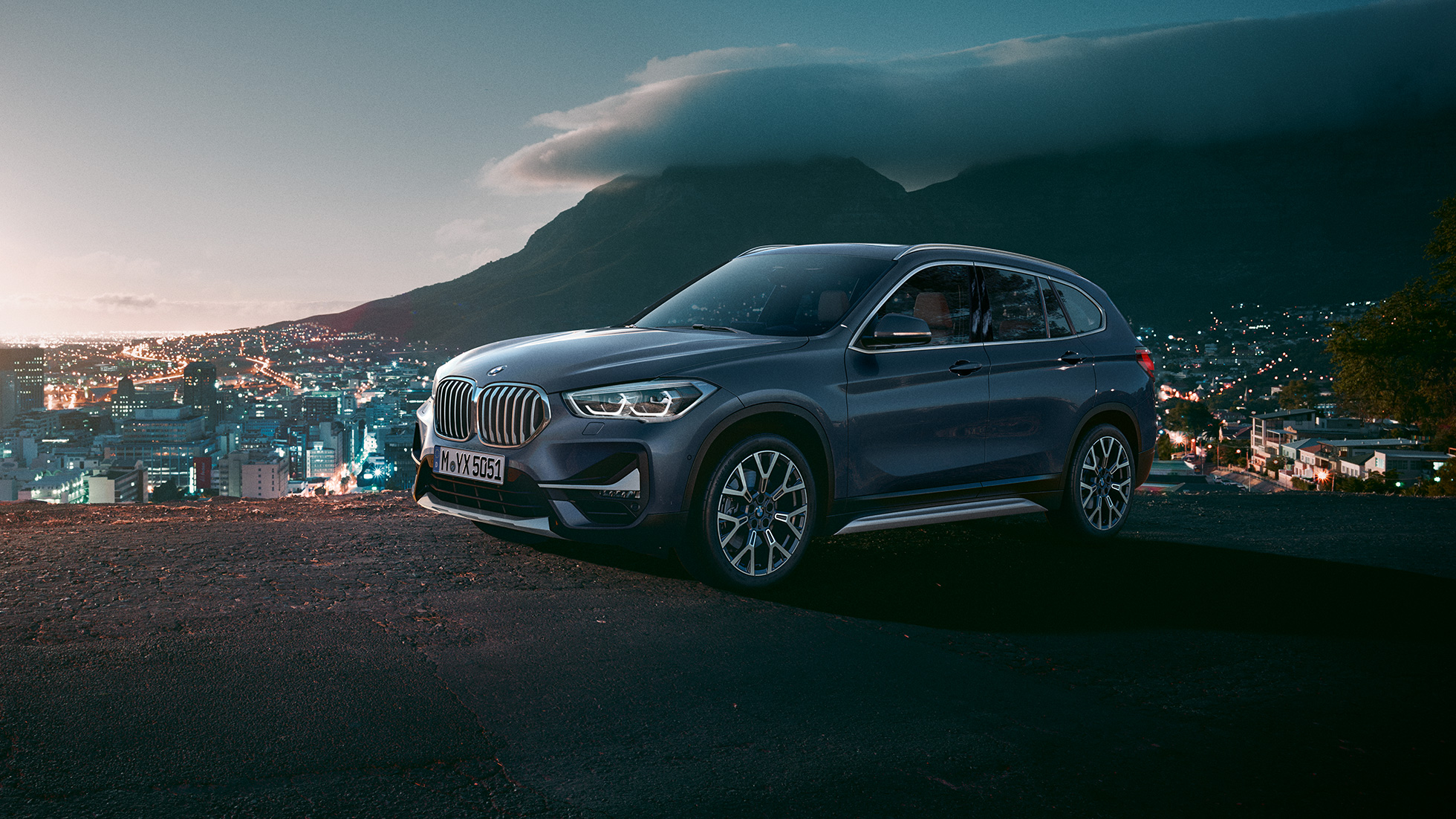 BMW X1, skásett sjónarhorn á hliðina. BMW X1, skásett sjónarhorn á hliðina með þéttbýli í bakgrunni.