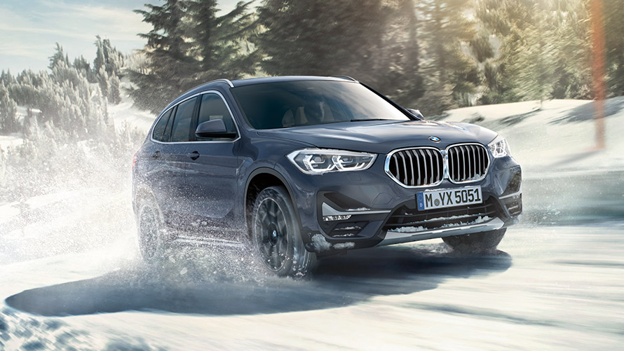BMW Individual-stormgrásanseraður BMW X1 xDrive20i F48 LCI við akstur í vetrarumhverfi BMW Individual-stormgrásanseraður BMW X1 xDrive20i F48 LCI við akstur í vetrarumhverfi