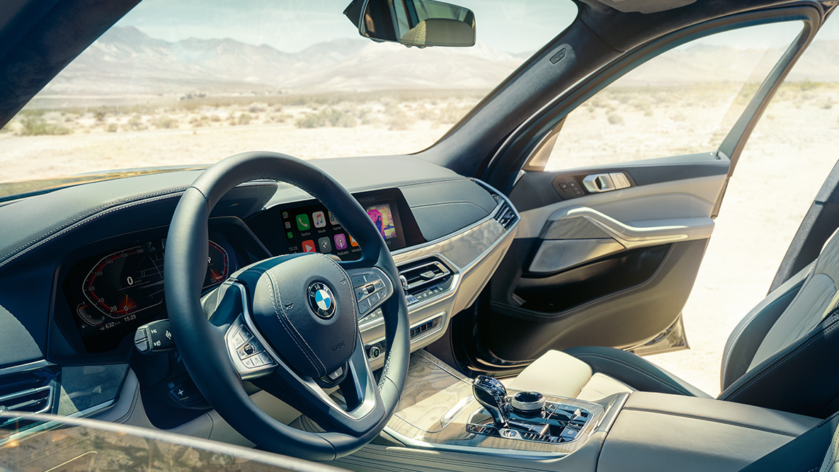 Innanrými BMW X7 Innanrými BMW X7: horft utan frá yfir fyrstu sætaröðina, stýrið, mælaborðið og leðursætin