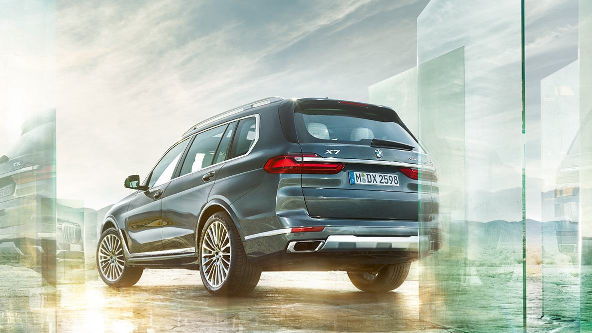 BMW X7, þægindi og aksturseiginleikar BMW X7, skásett sjónarhorn á afturhluta með abstrakt bakgrunni