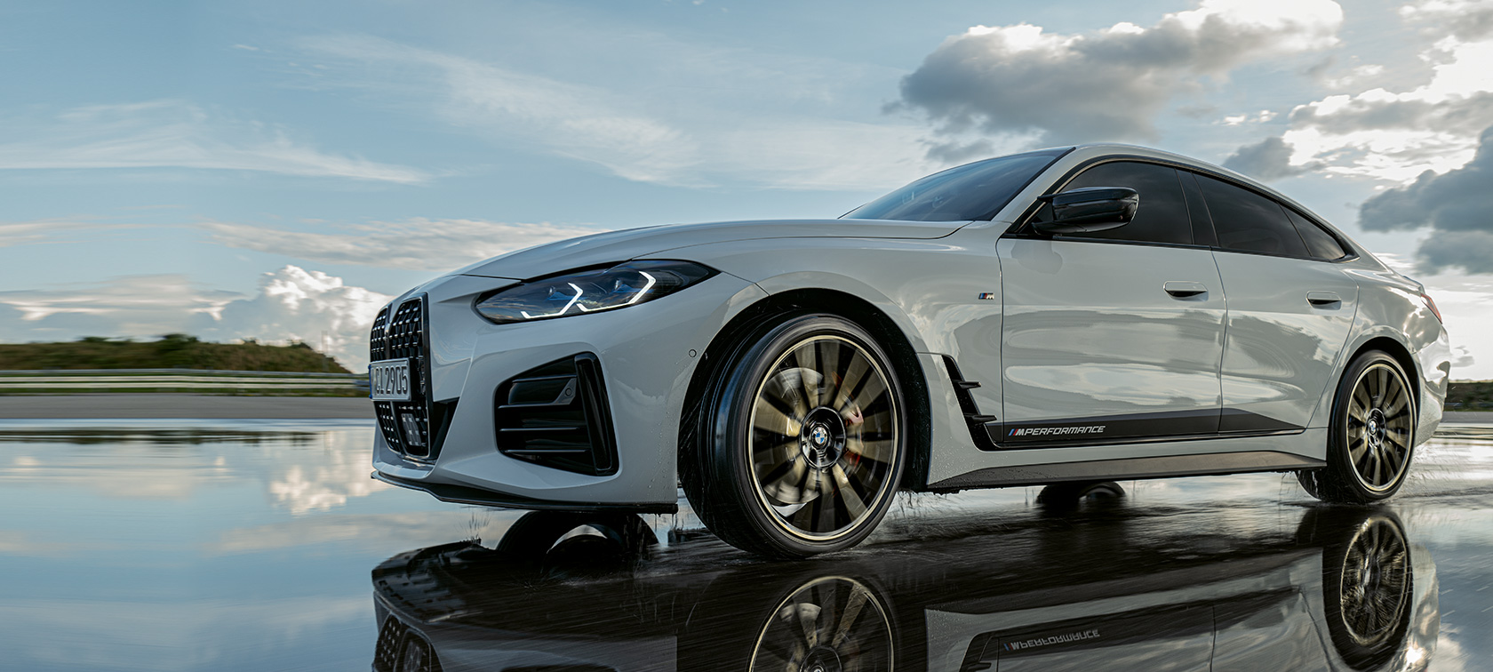 BMW 4 Series Gran Coupé (G26) með M Performance-hlutum ekur á blautri götu BMW 4 Series Gran Coupé (G26) með M Performance-hlutum ekur á blautri götu