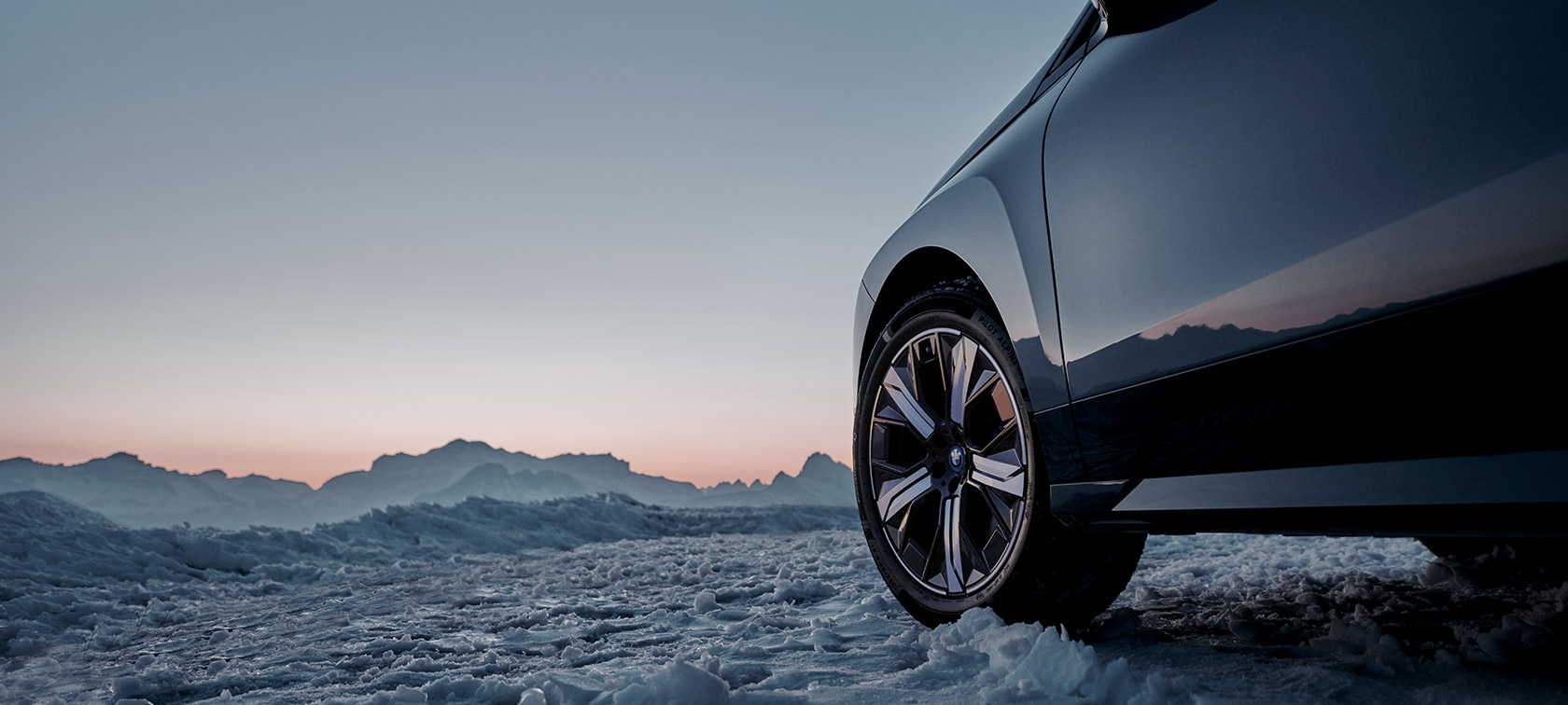 BMW-felgur á BMW iX (I20) á snjó með fjöll í bakgrunni