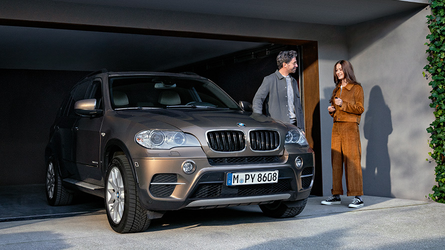 BMW-bíll fyrir framan bílskúr með fyrirsætum Value-þjónusta BMW BMW-bíll fyrir framan bílskúr með fyrirsætum