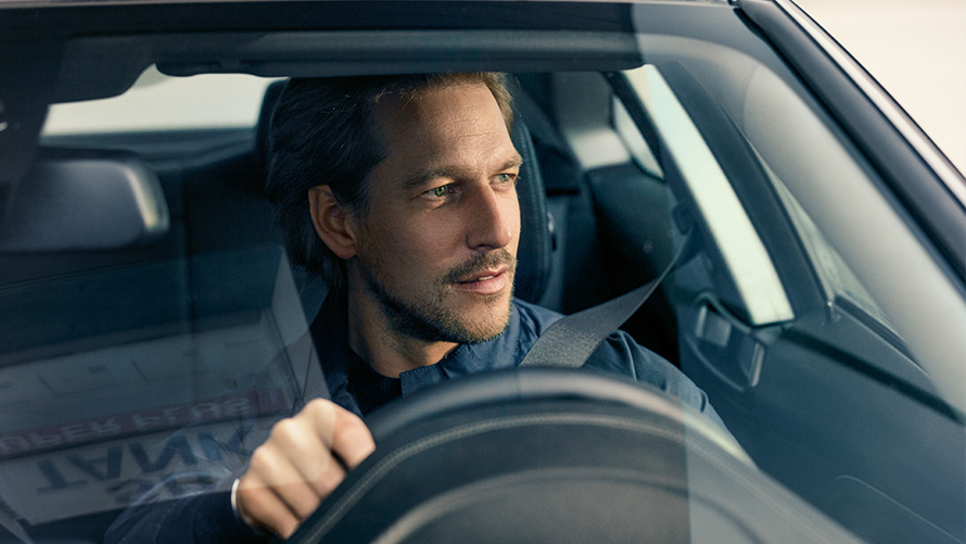 BMW Service Inclusive Man at the steering wheel of a BMW