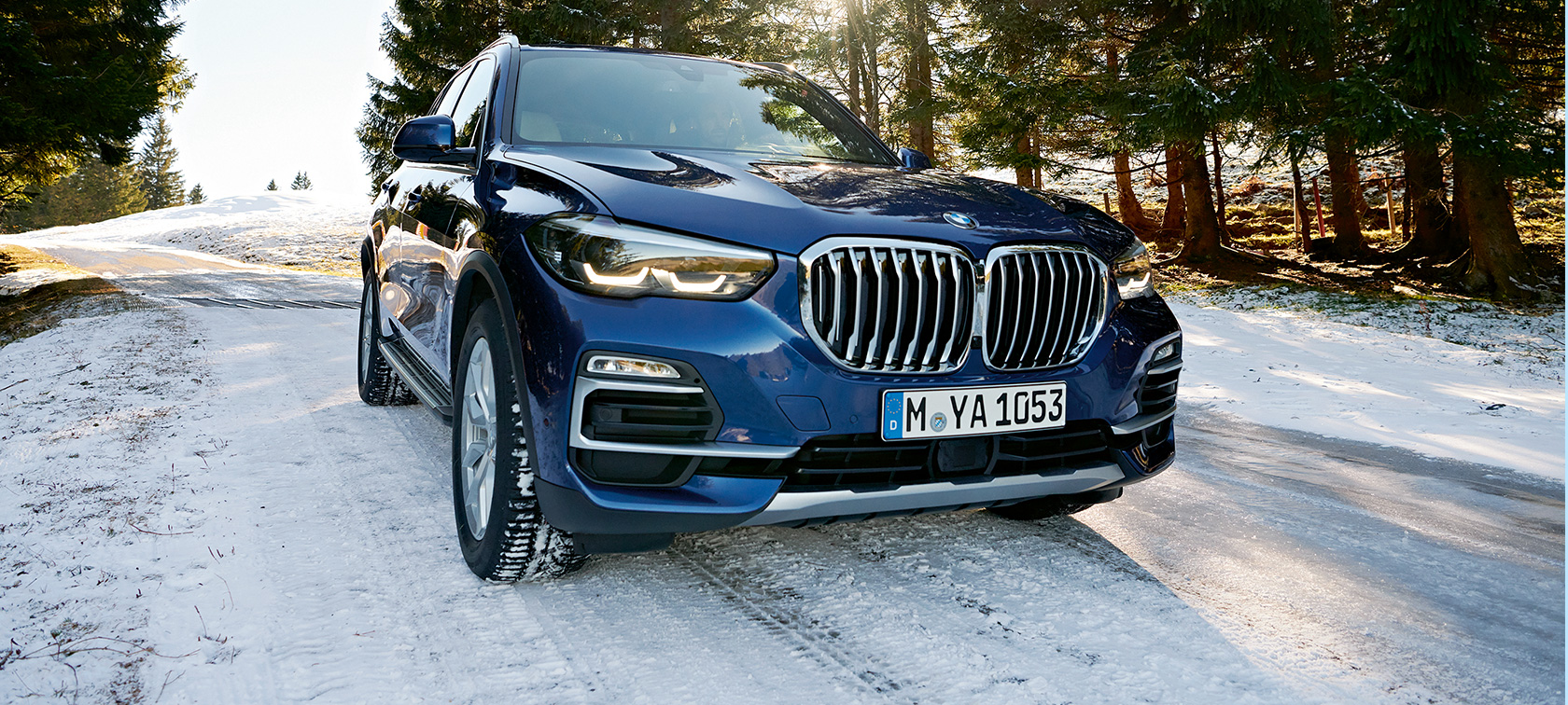 BMW Autumn and Winter Accessories BMW X3 in blue on snowy road, three-quarter front